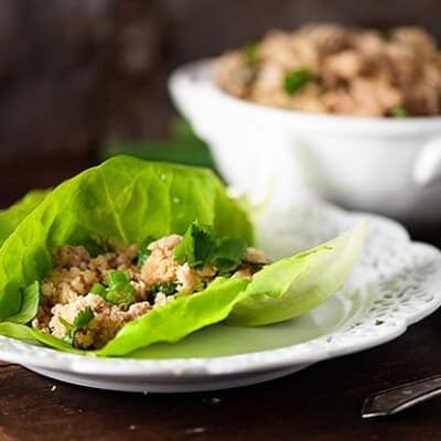 A large lettuce wrap with Asian chicken in the middle.