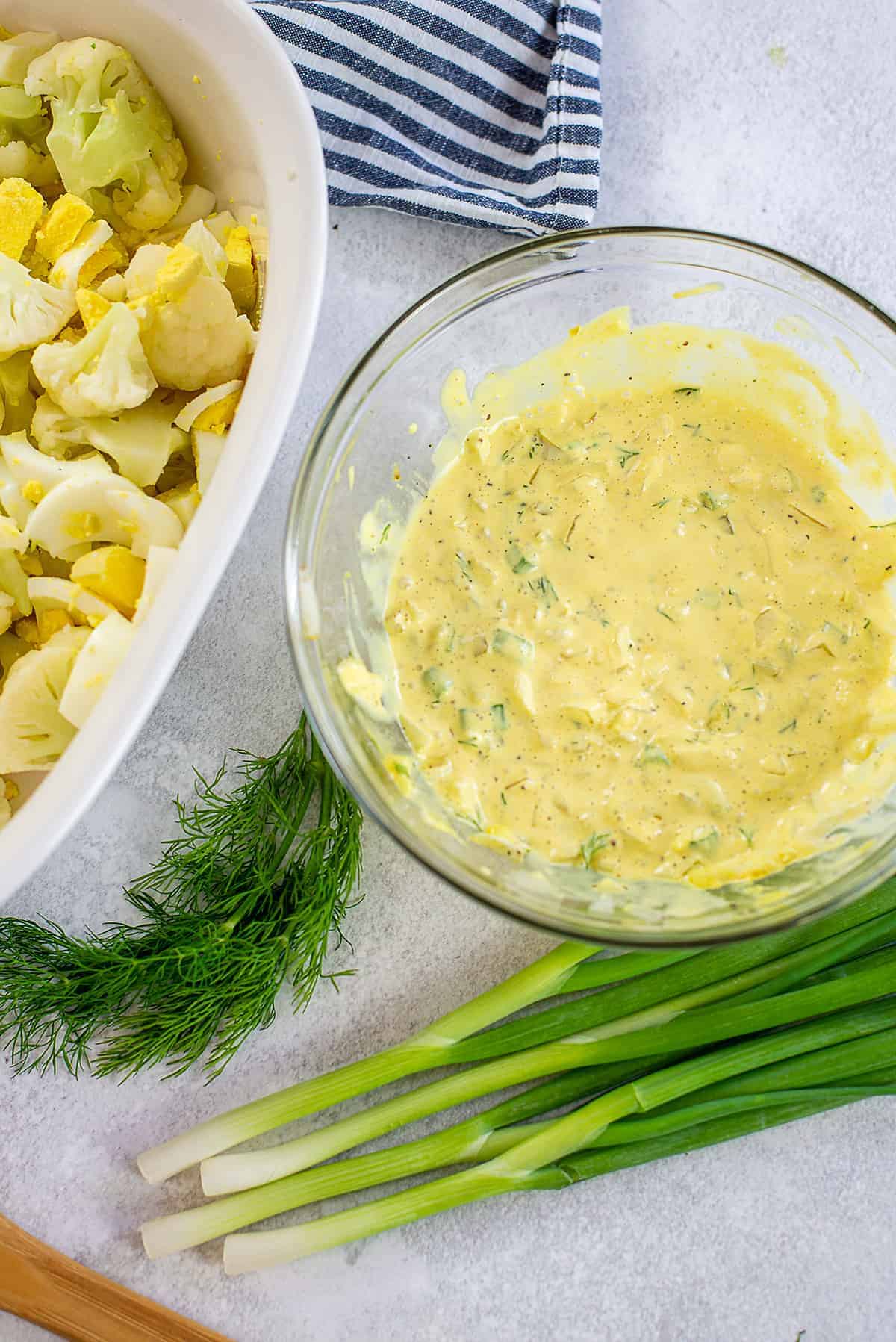 dressing for cauliflower potato salad in glass bowl.