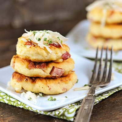 Three stacked up mini potato pancakes on a square plate.