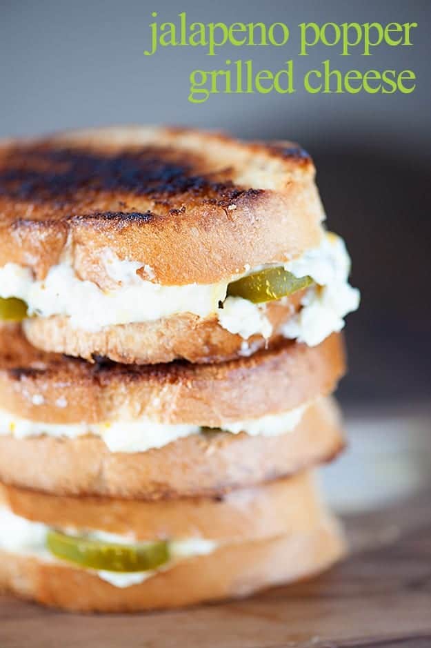 A close up of a grilled cheese sandwich with cream cheese and jalapenos in the middle.