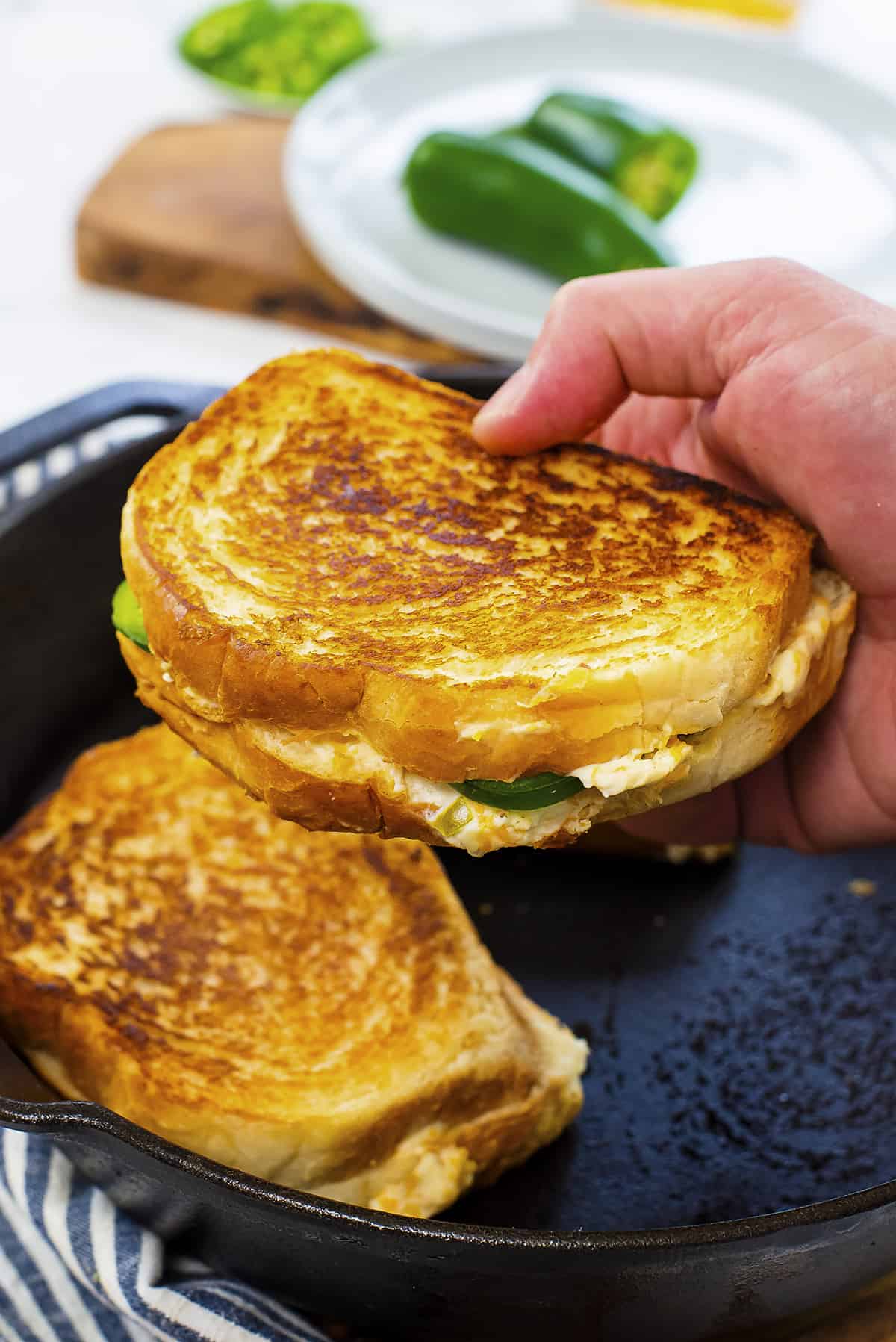 Hand holding a grilled cheese sandwich.