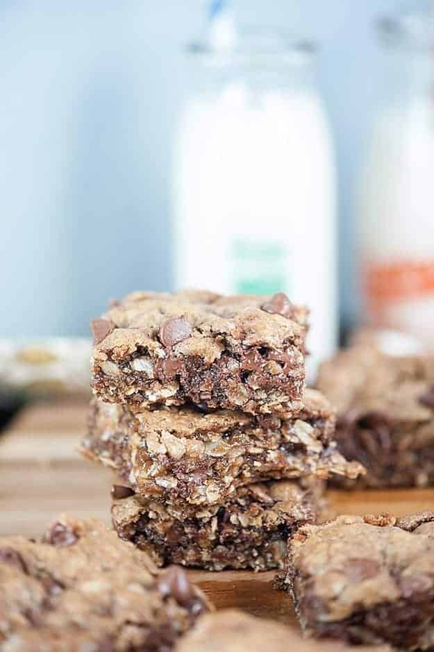 A stack of oatmeal cookie bars on a wooden cutting board.