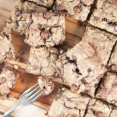 Several oatmeal cookie bars spread out over a cutting board.