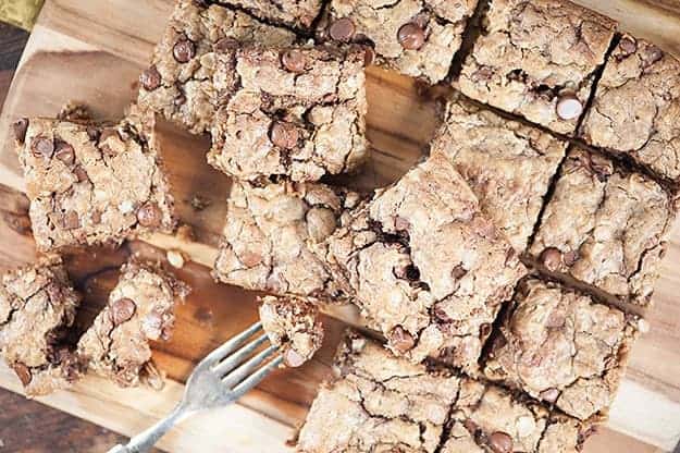 Several oatmeal cookie bars spread out over a cutting board.