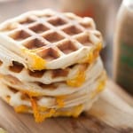 A stack of waffles with cheese in between them.