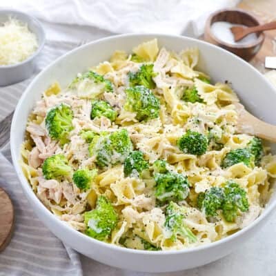 cheesy chicken and broccoli pasta in white bowl.