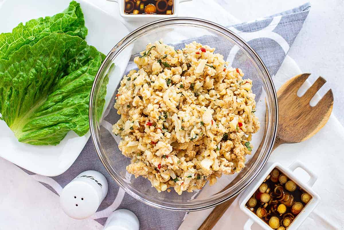 cauliflower rice mixed with chicken in glass bowl.