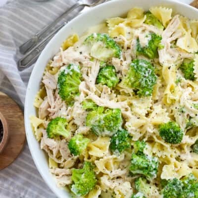 overhead view of chicken and broccoli pasta in white bowl.