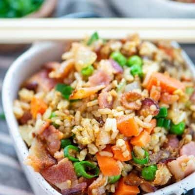bacon fried rice in small white dish with chopsticks.