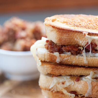 A close up of a few stacked up bacon jam sandwiches.