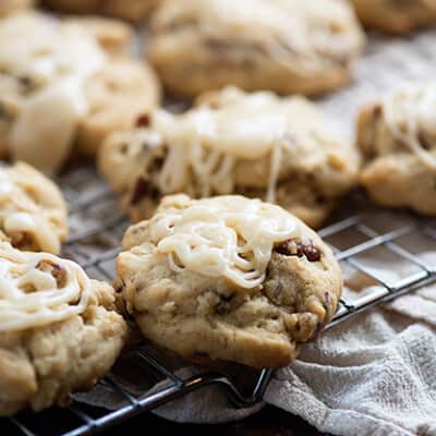 Cookies topped with icing on a wire cooling rack.