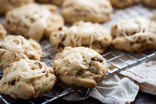 Cookies topped with icing on a wire cooling rack.