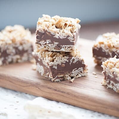 No bake chocolate bars stacked on a narrow cutting board.