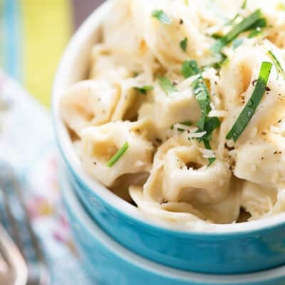 A close up of a bowl of tortellini alfredo.