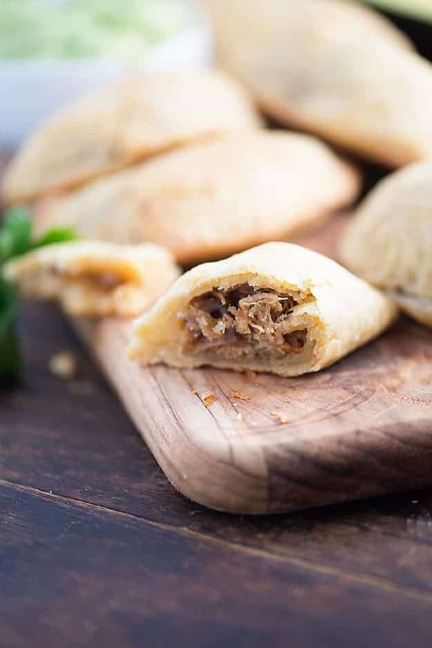 A close up of a cut empanada showing the carnitas filling.