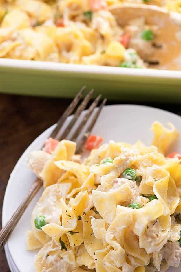 Chicken noodle casserole on a small white plate with a fork.