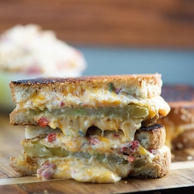 Two stacked halves of grilled tomato and cheese sandwich.