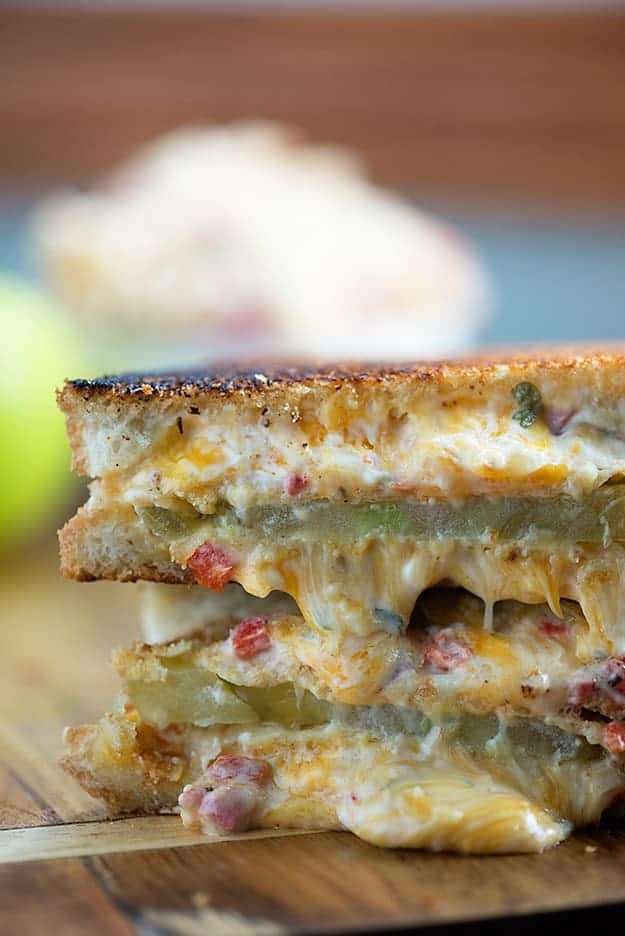 A close up of a cut in half and stacked up grilled cheese with tomato sandwich.