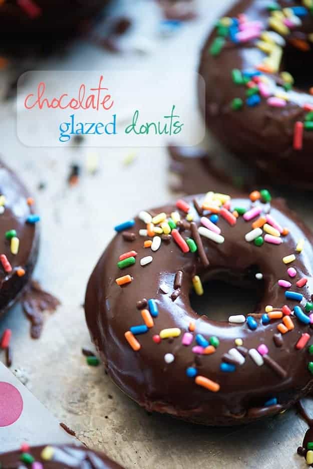 A close up of a chocolate doughnut sitting on top of a counter