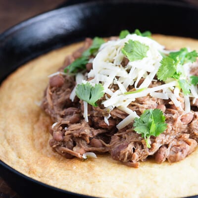 Slow cooker pork and beans! This is a cheap and easy slow cooker dinner that's perfect over cornbread. We love this for Mexican night!