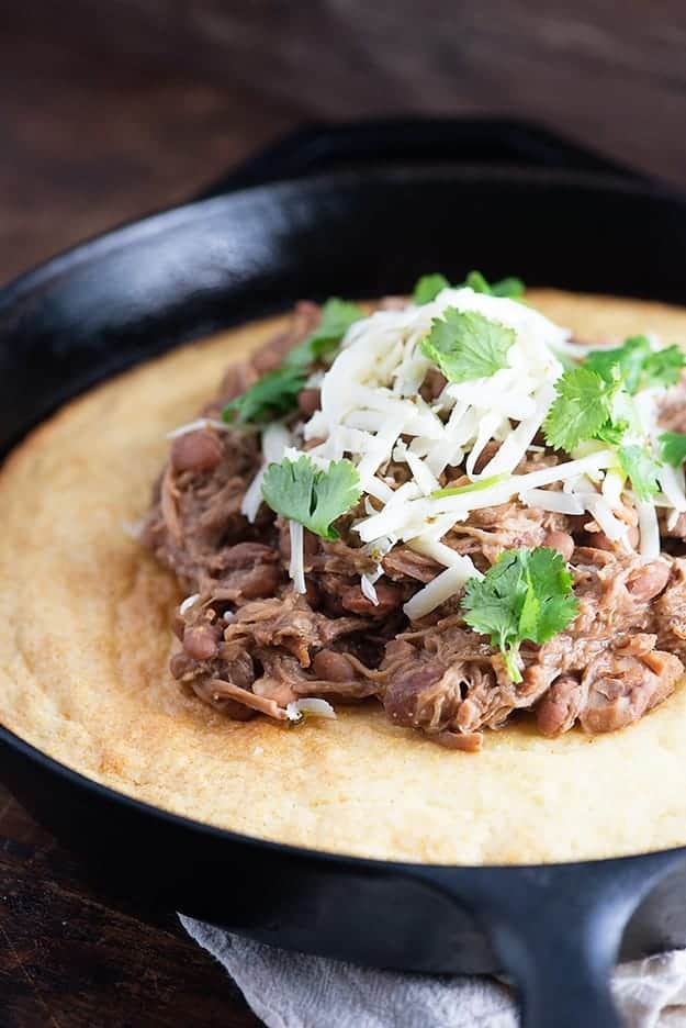 Slow cooker pork and beans! This is a cheap and easy slow cooker dinner that's perfect over cornbread. We love this for Mexican night! 