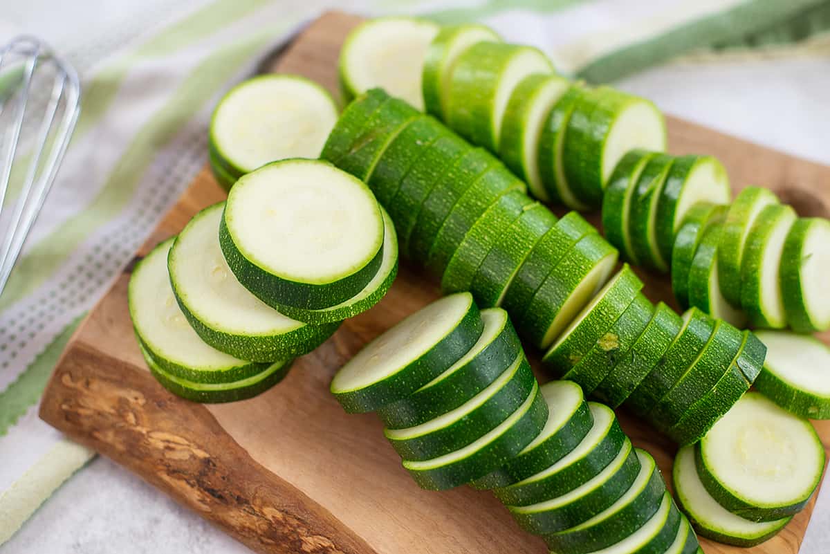 sliced zucchini on wooden cutting board.