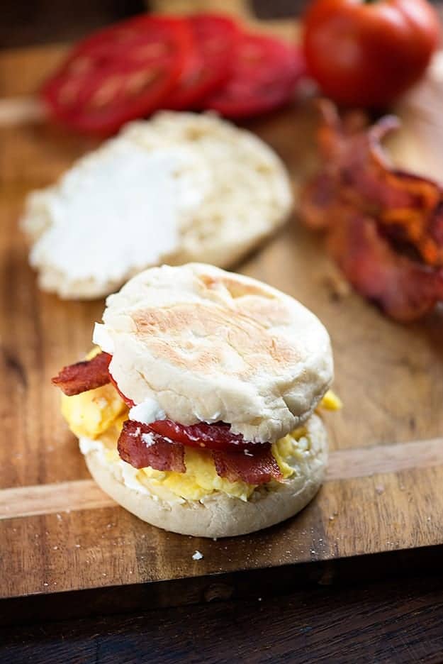 A BLT on an English muffin on a wooden cutting board 