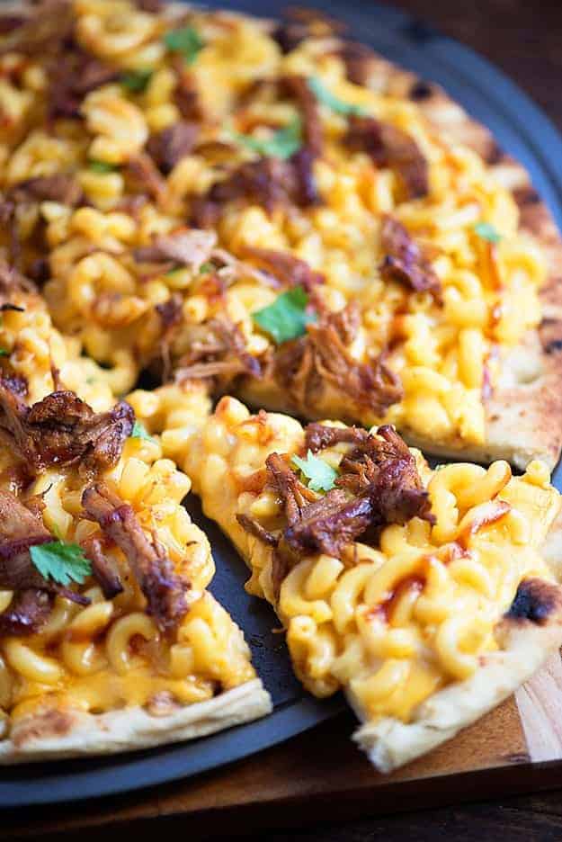 Macaroni and cheese and pulled pork pizza on a pizza pan.