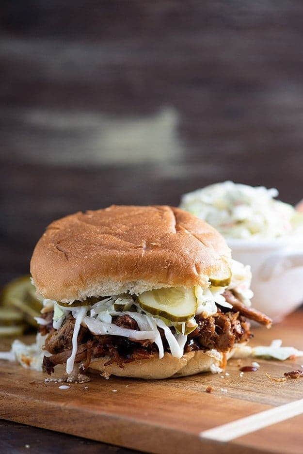 Pulled pork sandwich on a wooden cutting board.