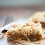 Close up of a pumpkin oatmeal bar on a wooden cutting board.