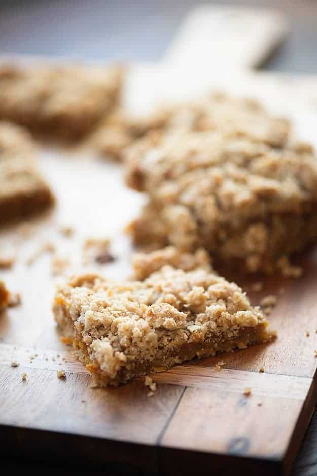 Several oatmeal cookie bars on a wooden cutting board.