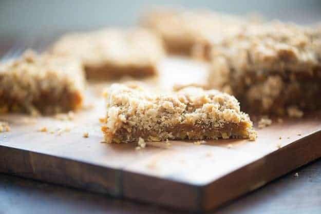 A close up of pumpkin oatmeal bars on a wooden cutting board.