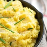 Light and fluffy baked mashed potatoes - the secret ingredient in these makes them so rich and dreamy! Perfect side dish for Thanksgiving.