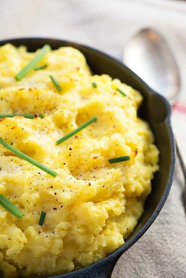 Light and fluffy baked mashed potatoes - the secret ingredient in these makes them so rich and dreamy! Perfect side dish for Thanksgiving.