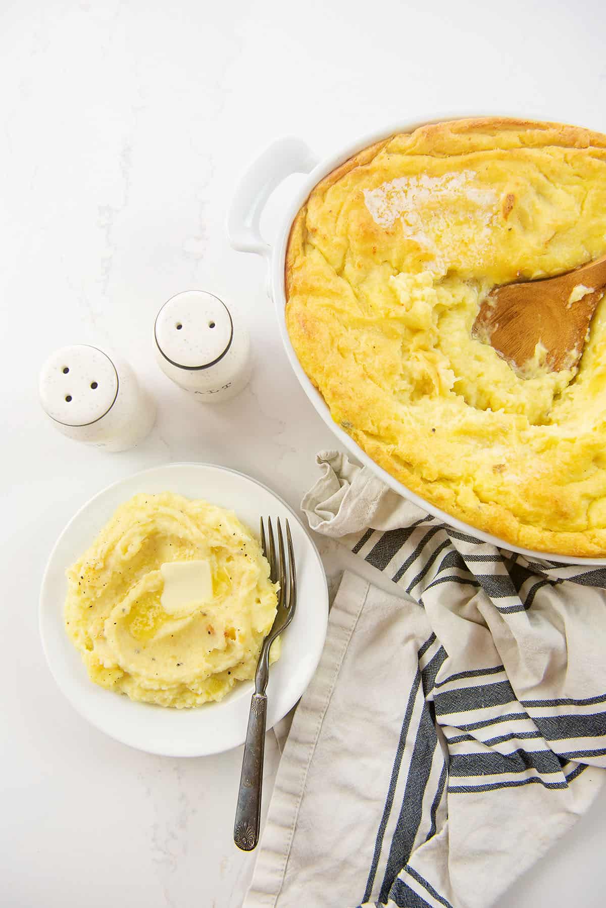 creamy baked potatoes on white plate.