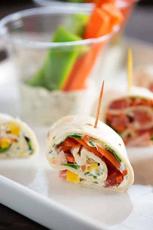 A close up of a vegetable roll up with a toothpick going through it.