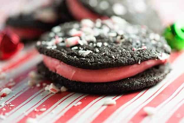 A close up of  two chocolate cookies with white cream in the middle on a table