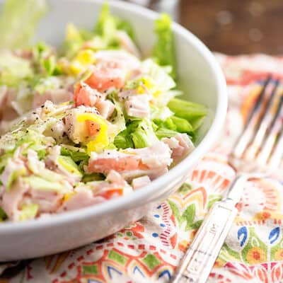 A white bowl of chopped salad on a cloth napkin.