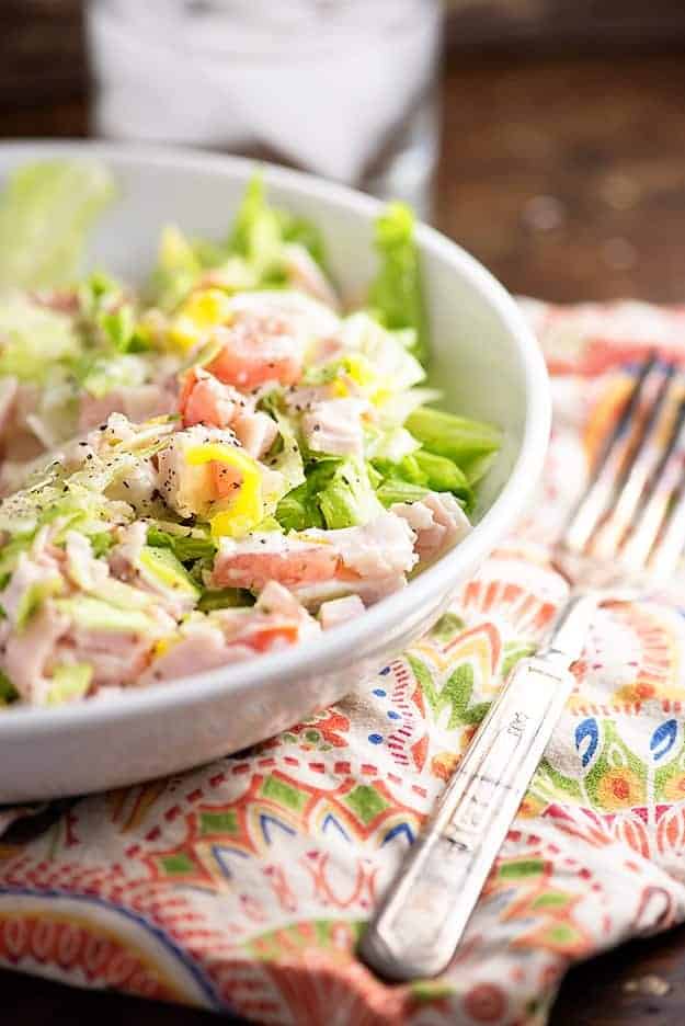 A white bowl of chopped salad on a cloth napkin.