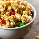 A bowl of popcorn with red and white M&M's in it.