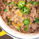 A large pot full of refried beans with jalapenos.