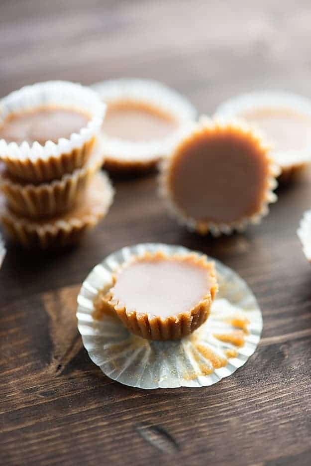 One unwrapped piece of fudge in front of several wrapped pieces stacked up.