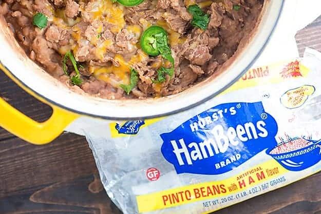 A pot of refried beans next to an empty bag of beans.