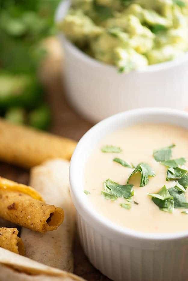 A white cup of queso dip.