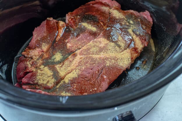beef and seasoning in crockpot.
