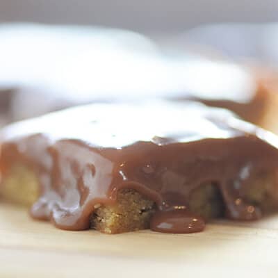 Melted fudge on top of a square of blondies.