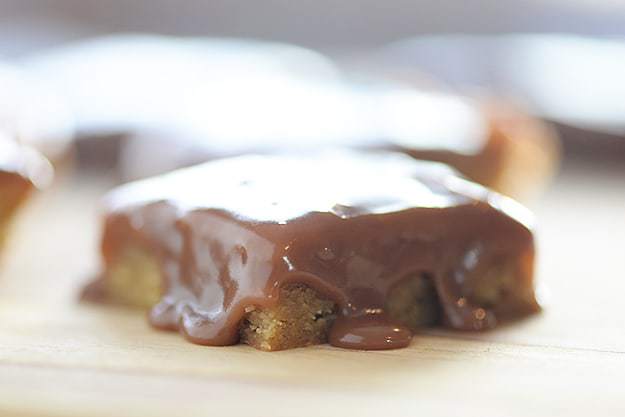 Melted fudge on top of a square of blondies.