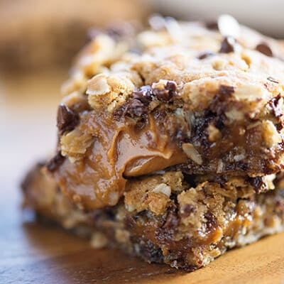 A close up of a couple oatmeal cookie bars stacked up.