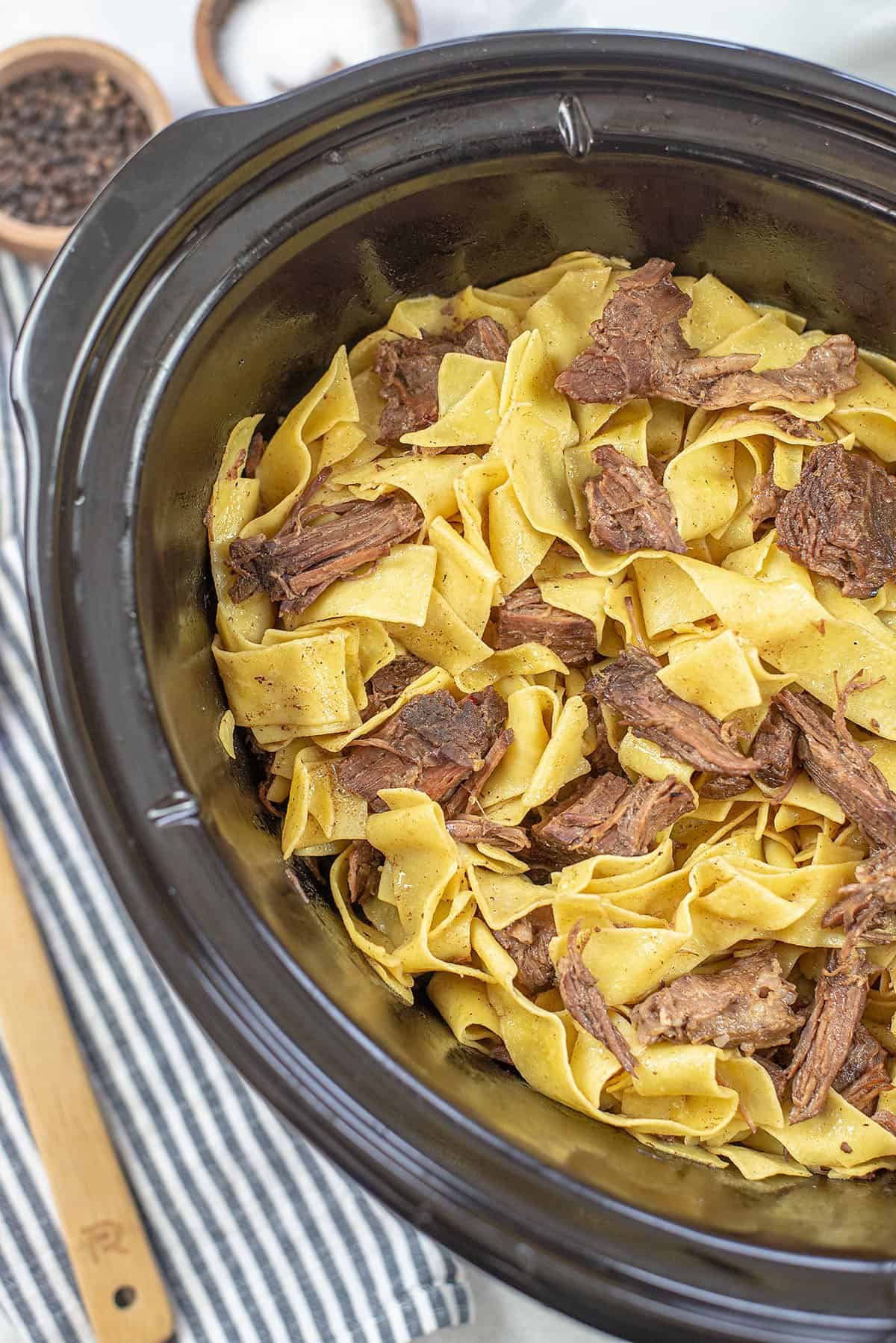 overhead view of beef and noodles in crockpot.