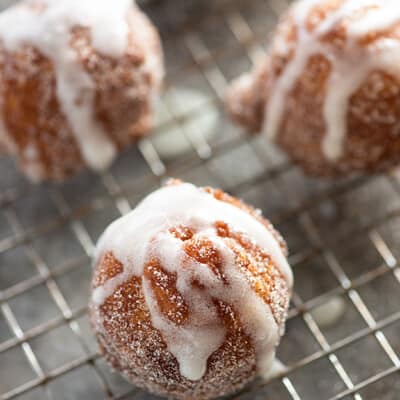 A donut hole on a wire cooling rack.